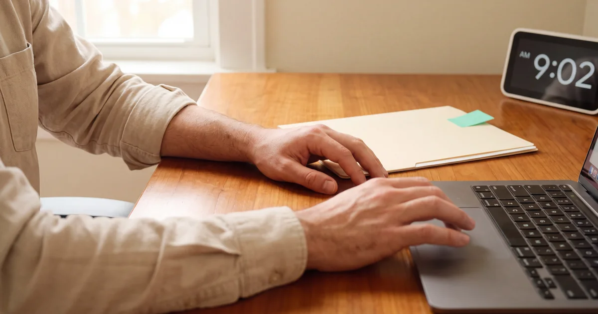 How to Speed Up Prior Authorization for Specialists Person completing prior authorization work at a laptop beside a digital clock